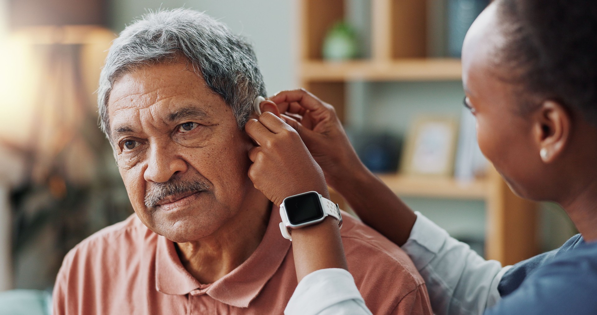 Nurse, patient and hearing aid on ear for medical support, wellness or innovation of disability. People, healthcare worker or deaf man with audiology implant, check and service or help for sound wave Nurse, patient and hearing aid on ear for medical support, wellness or innovation of disability. People, healthcare worker or deaf man with audiology implant, check and service or help for sound wave